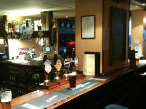 a bar with bottles of alcohol on a counter at The George Hotel in Newent