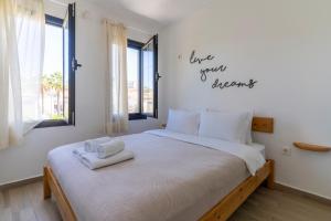 a bedroom with a bed with two towels on it at Naro Suites Çeşme Marina in Çeşme