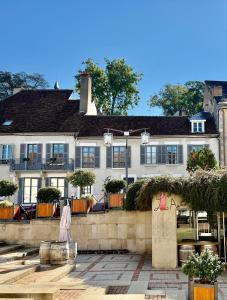 ein großes weißes Haus mit einer Steinmauer in der Unterkunft Maison Palomase en plein cœur de Sancerre in Sancerre