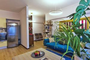 a living room with a blue couch and a kitchen at Al Ventidue in Varese