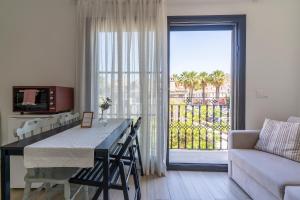 a living room with a table and a large window at Naro Suites Çeşme Marina in Çeşme