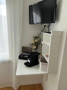 a white shelf with a television on a wall at Gästehaus MaryVitty, zentrale zwischen Aarau und Olten, gut verbunden in Schönenwerd +24 photos