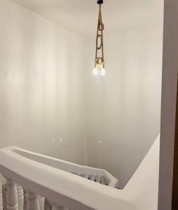 a white staircase with a chandelier hanging over it at Bellimena Stone Town in Zanzibar City