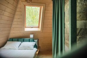 Una cama en una habitación de madera con ventana. en Domy kopułowe, 