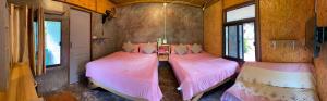 two beds in a small room with pink sheets at สบายดีแม่กลางหลวง in Ban Sop Mae Klang +1 photo