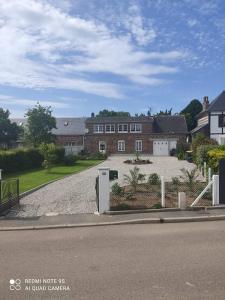 una strada vuota con una casa e un vialetto di maison des papillons a Tourville-la-Chapelle