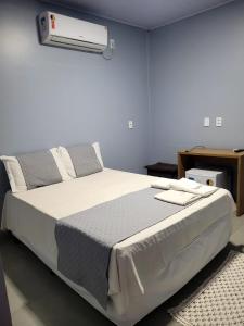 a bedroom with a large bed with a air conditioner at POUSADA ALÉM-K in Riachão +72 photos