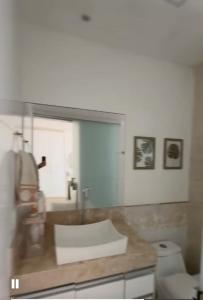 a bathroom with a counter top and a toilet at Casa Sol & Mar Guriri in São Mateus