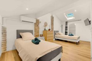 a bedroom with two beds and a dresser in it at Les Chambres du Pays Toulousain in Pechbonnieu