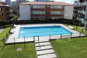 a large swimming pool with stairs next to a building at Apartamentos Zarautz Playa4, con piscina y garaje in Zarautz