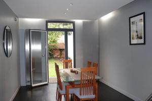 una sala da pranzo con tavolo, sedie e una finestra di House sleeps 5 Orly Airport Paris ad Arcueil Altre 17 foto