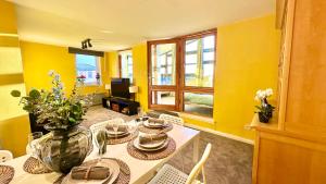 a dining room with yellow walls and a table and chairs at Sunny day new flat with 5 beds in Clydebank +35 photos