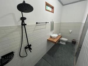 a bathroom with a shower with a sink and a toilet at Kuta Lodge Homestay in Kuta Lombok +38 photos