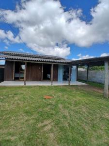 a house with a lawn in front of it at Recanto Doce Lar in Passo De Torres +8 photos