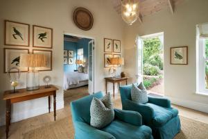 a living room with a blue couch and a bed at La Cotte Orchard Cottages in Franschhoek +66 photos
