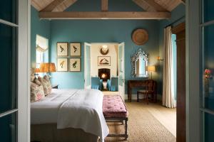 a bedroom with blue walls and a large bed at La Cotte Orchard Cottages in Franschhoek +66 photos