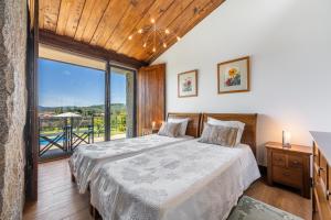 Un dormitorio con una cama y una ventana grande. en Villa 206, en Paredes de Coura 72 fotos más