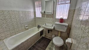 a bathroom with a tub and a toilet and a sink at House Accommodation in Sasolburg +20 photos