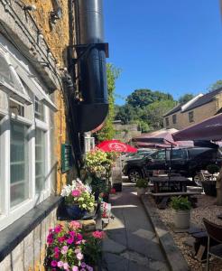 a building with flowers on the side of it at The George Hotel in Castle Cary