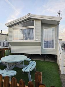 une maison avec une table de pique-nique et des chaises dans la cour dans l'établissement 211 Holiday Resort Unity 6 berth Passes Optional No Pets, à Brean