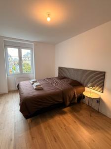 a bedroom with a large bed and a table at Vue imprenable - Place de la République in Belfort