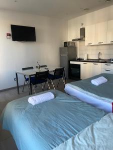two beds in a room with a table and a kitchen at La Casa di Anna in Delebio +40 photos