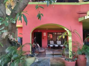 a pink building with plants in front of it at Apart-Hotel Costa Verde in Costa Verde