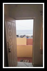 une porte ouverte sur une pièce avec vue sur l'océan dans l'établissement Mubeen beach villa, à Pondichéry