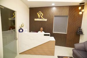 Ein Mann, der an einem Tresen in einer Zahnarztpraxis sitzt. in der Unterkunft Hotel Visawa Residency in Kolhapur