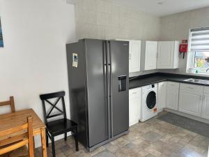 a kitchen with a stainless steel refrigerator and a table at Spacious Luxurious Serviced Accomodation in Doncaster