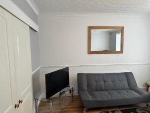 een woonkamer met een bank en een spiegel bij Spacious Luxurious Serviced Accomodation in Doncaster