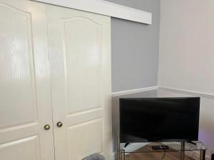 een televisie in een kamer met een witte deur bij Spacious Luxurious Serviced Accomodation in Doncaster