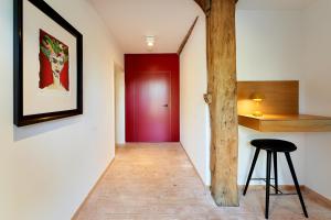 a hallway with a red door and a stool at zimmer437 in Varel