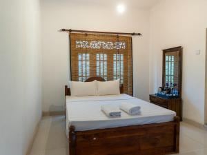 a bedroom with a bed with two towels on it at Moi Dambulla by DBI in Dambulla