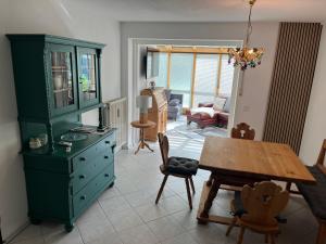 a living room with a green cabinet and a table at Ferienwohnung Gisela in Kolbermoor