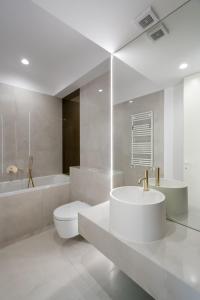 ein Badezimmer mit Waschbecken, Toilette und Badewanne in der Unterkunft Elegant Studio Cortina Modern Stay in Voluntari + 27 Fotos