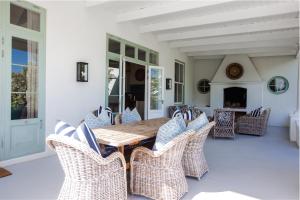 a dining room with a wooden table and wicker chairs at La Cotte Orchard Cottages in Franschhoek