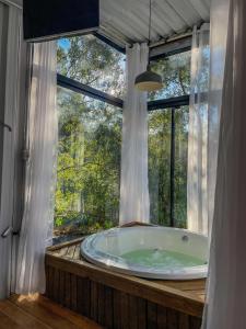 a bathroom with a tub in front of a window at Container Dos Sonhos in Rio Forcação +141 photos