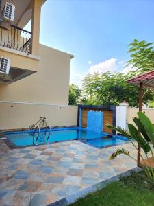 a swimming pool in the backyard of a house at Ananda stays in Debāri +10 photos
