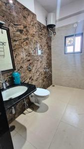 a bathroom with a white toilet and a sink at Ananda stays in Debāri
