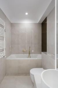 ein weißes Badezimmer mit Badewanne und Toilette in der Unterkunft Elegant Studio Cortina Modern Stay in Voluntari