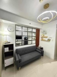 a living room with a couch and a large window at Sea Residences Xyrille in Manila
