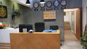 an office with a desk with clocks on the wall at Clifton Events Business Hotel in Karachi