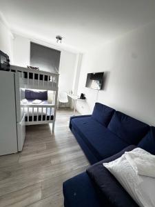 a living room with a blue couch and a crib at Family room in Zone 2 in London +1 photo