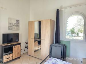 a living room with a tv and a mirror at LE BARCARES Maison pour 3 personnes Casa para 3 personas House for 3 people in Le Barcarès