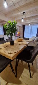 a wooden table with chairs and a plant on it at Domek Nebiosso z Balią in Sosnówka
