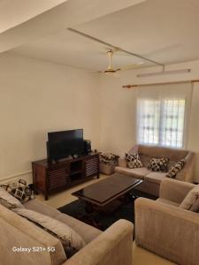 a living room with couches and a flat screen tv at PremierStays in Mombasa +7 photos