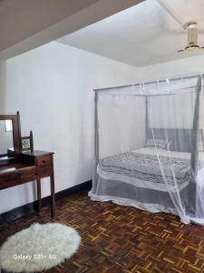 a bedroom with a bed with a mosquito net at PremierStays in Mombasa