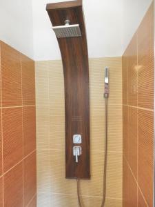 a shower in a bathroom with a wooden wall at Orange Bamboo Suite in Split