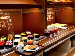a buffet line with different types of food at B&B HOTEL Rostock-Broderstorf in Rostock